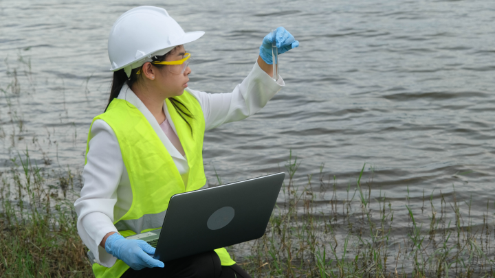 Laboratory technician analyzing water sample for environmental contaminants using modern testing equipment