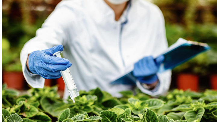 Technician conducting environmental testing of air, water, and soil in laboratory using advanced equipment